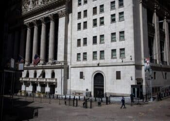 A trader walks in front of the New York Stock Exchange. Photographer: Michael Nagle/Bloomberg