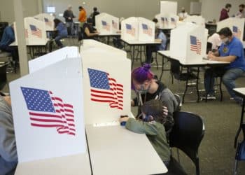 Voters wearing protective masks cast ballots at a polling location for the 2020 Presidential election in Des Moines, Iowa, U.S., on Tuesday, Nov. 3, 2020. American voters, at least those who've not yet cast ballots, go to the polls Tuesday to choose between President Donald Trump and Democratic nominee Joe Biden and cast votes in U.S. House and Senate races and state and local elections. Photographer: Rachel Mummey/Bloomberg