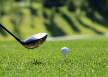 Golf club teeing up a golf ball
