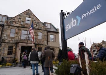 Customers wait in line outside of a Silicon Valley Bank branch in Wellesley, Massachusetts, US, on Monday, March 13, 2023. The collapse of Silicon Valley Bank has prompted a global reckoning at venture capital and private equity firms, which found themselves suddenly exposed all together to the tech industry's money machine. Photographer: Sophie Park/Bloomberg