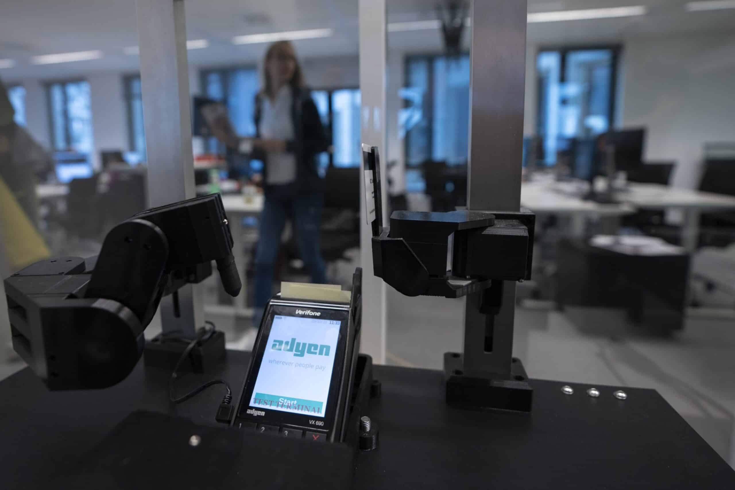 A robotic arm sits beside a contactless payment processing device, manufactured by VeriFone Systems Inc., in the testing room inside the Adyen NV headquarters in Amsterdam, Netherlands, on Monday, Oct. 29, 2018. Investors have flocked to fintech company Adyen, whose shares have risen from 240 euros at the time of the IPO, to as much as 609 euros a month later.