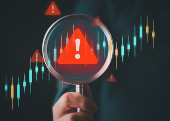 a magnifying glass enlarges a red triangle with an exclamation point in it
