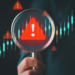 a magnifying glass enlarges a red triangle with an exclamation point in it