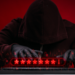 a shadowy figure types a password into a keyboard